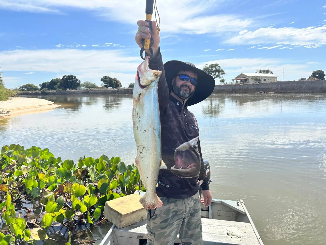 Pescador sorrindo com um tucunaré